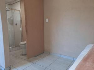 Un baño con ducha y WC. en Cozy Airport Stay, en Kempton Park