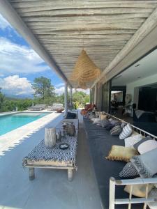 een woonkamer met banken en een zwembad bij Bali-style Pool Villa in Residence in Valbonne