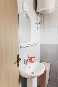 een badkamer met een witte wastafel en een spiegel bij Guest House Lalic in Bar