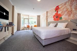 ein Hotelzimmer mit einem Bett und einem TV in der Unterkunft Fletcher Hotel-Restaurant De Scheperskamp in Lochem