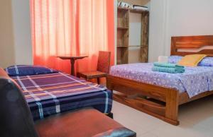 1 dormitorio con 2 camas individuales y 1 silla en Hostal Killa360 Luna, en Santa Cruz de la Sierra