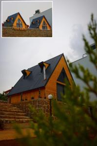 a barn with a black roof and steps in front at Azhara Bungalov in Pelitli