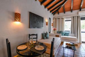 a living room with a table and a couch at Pedras Da Rainha in Cabanas de Tavira