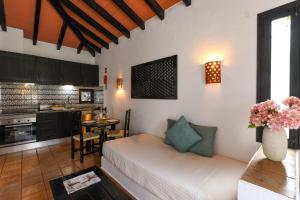 a living room with a couch and a kitchen at Pedras Da Rainha in Cabanas de Tavira