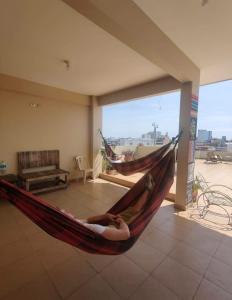 a woman laying in a hammock in a living room at Hostal Killa360 Luna in Santa Cruz de la Sierra