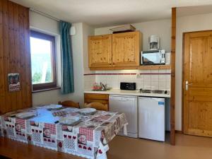 a small kitchen with a table and a counter top at Appartement Morillon 1100, 2 pièces, 7 personnes - FR-1-624-100 in Morillon