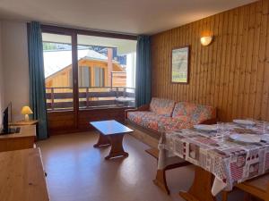 a living room with a couch and a table at Appartement Morillon 1100, 2 pièces, 7 personnes - FR-1-624-100 in Morillon
