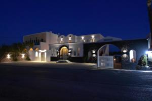 a large white house at night with lights at Rodakas Hotel in Akrotiri