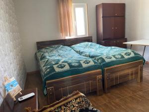 a bedroom with a bed with blue sheets and a window at Aloha House in Akhaltsikhe