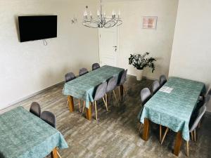 une salle de conférence avec deux tables et des chaises ainsi qu'une télévision dans l'établissement Smerichka, à Bukovel