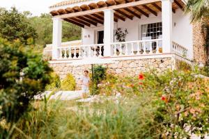 Villa B&M Experience في Sant Francesc de s'Estany: امرأة تقف على شرفة منزل