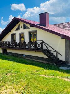 a house with a balcony and a red roof at Smerichka in Bukovel