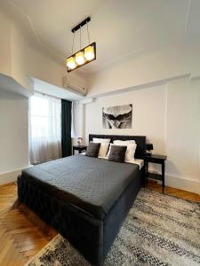 una camera da letto con un grande letto nero e una finestra di City View - Luxury Apartment - Sanador Victoriei a Bucarest
