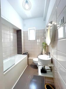 bagno con lavandino, vasca e servizi igienici di City View - Luxury Apartment - Sanador Victoriei a Bucarest
