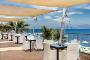 eine Terrasse mit Tischen und Stühlen und Meerblick in der Unterkunft Labranda Ephesus Princess - All Inclusive in Kusadası