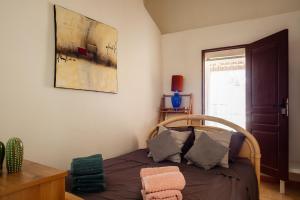 a bedroom with a bed and a picture on the wall at La Maison Méditerranéenne in La Ciotat