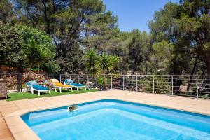 a swimming pool with two chairs and a fence at La Maison Méditerranéenne in La Ciotat