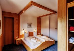 Schlafzimmer mit einem Bett und einem großen Spiegel in der Unterkunft Pension Uga in Damüls