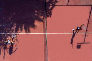 2 personnes tenant des raquettes de tennis sur un court de tennis dans l'établissement Labranda TMT Bodrum, à Bodrum City