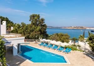 a pool with chairs and a view of the water at Labranda TMT Bodrum in Bodrum City