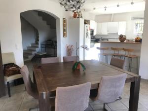 una cucina e una sala da pranzo con tavolo e sedie in legno di Solio a Meyrargues