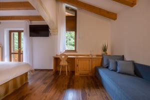 a bedroom with a bed and a couch and a desk at Hotel Stalon Alpine Chic in San Martino di Castrozza