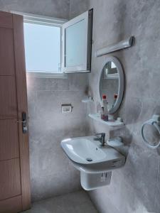 y baño con lavabo y espejo. en Family corner1, en Ḩammām al Ghazzāz