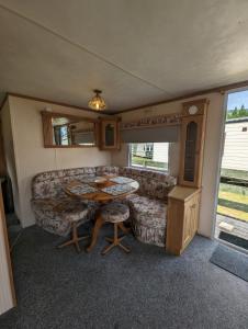 a living room with a couch and a table at 30 Glenfinart Caravan Park in Dunoon