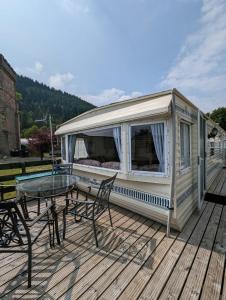a mobile home with a table and chairs on a deck at 30 Glenfinart Caravan Park in Dunoon