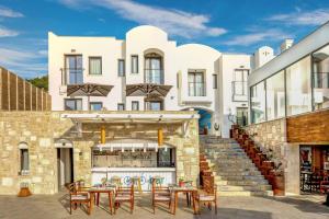 a building with a patio with tables and chairs at Senses Hotel - Adults Only in Bodrum City