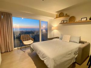 una camera da letto con un letto e una grande finestra di Cabien Zeedijk Oostduinkerke a Oostduinkerke