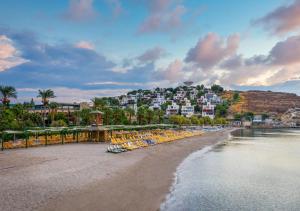 a beach with chairs and condos in the background at Selectum Collection Bodrum in Akyarlar