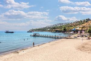 a beach with a pier and people in the water at Selectum Collection Bodrum in Akyarlar