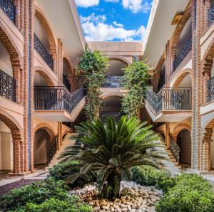 a courtyard with a palm tree in a building with balconies at Selectum Collection Bodrum in Akyarlar