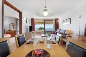 a dining room and living room with a table and chairs at Maravilla Over the Ocean in Costa Del Silencio