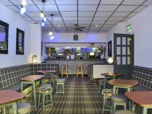 un restaurante con mesas y taburetes y un bar en Granville Hotel, en Blackpool