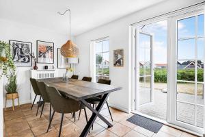 - une salle à manger avec une table et des chaises en bois dans l'établissement Charming Architect-designed Terraced House With Sea View, à Bro