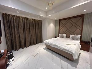 a bedroom with a large bed and a large window at Hotel AR Inn in Thane