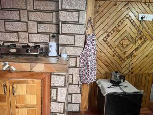 a kitchen with a counter and a wall with a stove at Be my guest at Hills in Kulu