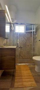 een badkamer met een douche, een wastafel en een toilet bij The Byzantine Wall House in Isthmia