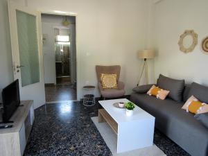 a living room with a couch and a tv at The Byzantine Wall House in Isthmia