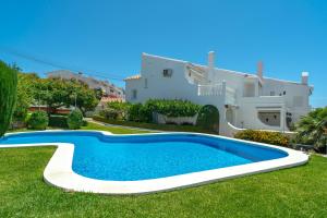 a villa with a swimming pool in front of a house at Los Aguacates Bellavista Casasol in Nerja