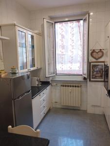 a kitchen with a refrigerator and a window at Casa Nonna Anna in Genoa