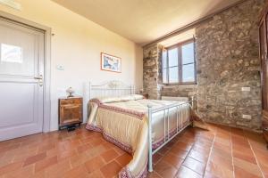 een slaapkamer met een bed en een stenen muur bij Dimora Schioppo - Irpinia in Calitri