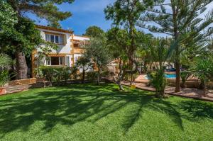 een huis met een tuin met bomen en een zwembad bij Ideal Property Mallorca - Sol de Mallorca 1 in Cala Mesquida
