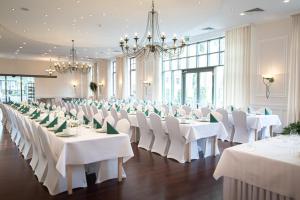 a banquet hall with white tables and white chairs at 4 Pory Roku Resort Sauna & Spa in Bąkowo