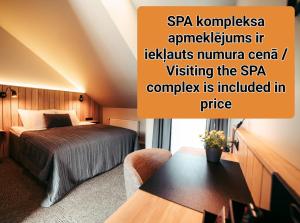 ウスマにあるUsma SPA Hotel & Campingのベッドとテーブルが備わるホテルルームです。