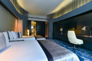 a hotel room with a large bed and a desk at W Doha in Doha