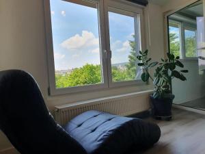 a living room with a chair and a large window at Ferienwohnung mit Weitblick in Weiskirchen