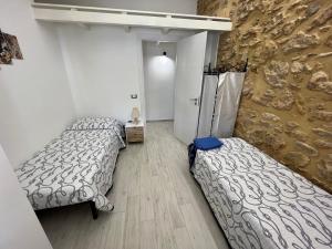 - 2 lits dans une chambre avec un mur en pierre dans l'établissement Villa Sovareto, à Sciacca